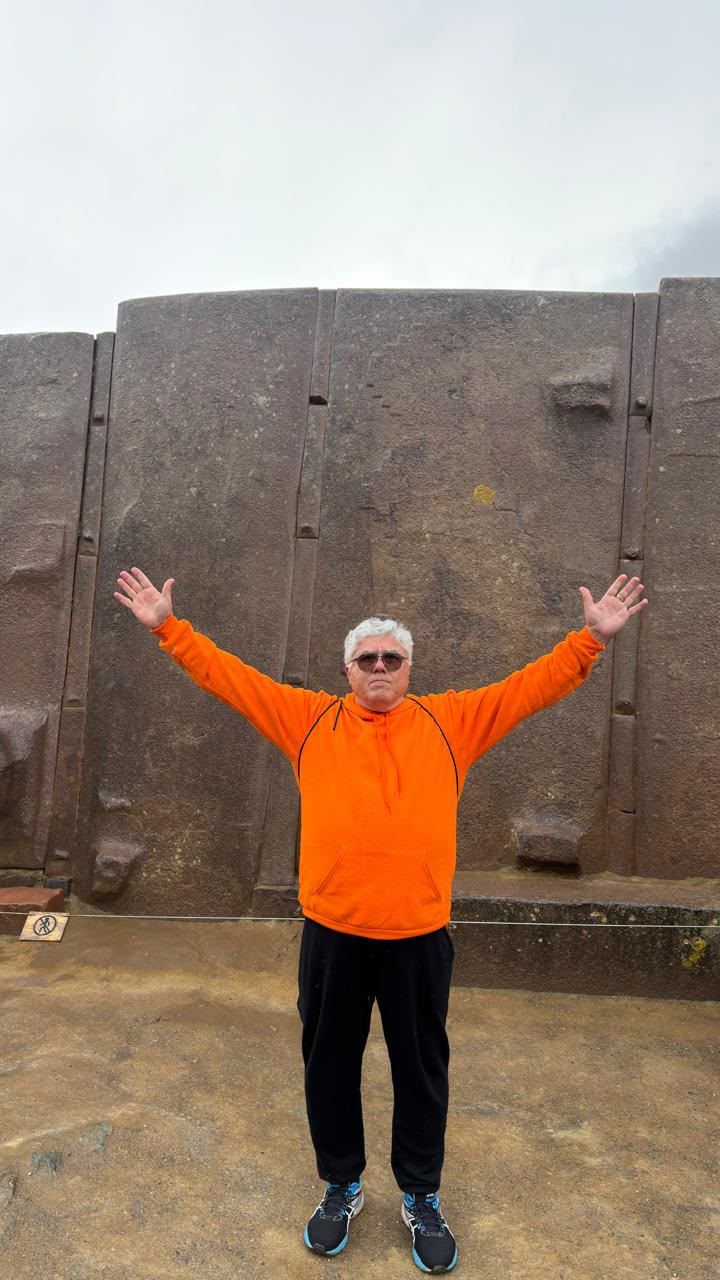 Grandes monólitos de pedra encaixados, com Francisco de braços abertos diante deles